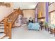 Bright living room with a cozy fireplace, tall windows, elegant staircase, and comfortable seating at 1497 N 200 W, Greenfield, IN 46140