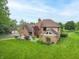 An aerial of the back of a brick home with an outdoor patio and green lawn at 1497 N 200 W, Greenfield, IN 46140