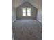 Spacious bedroom featuring dormer windows, gray walls, and modern gray carpeting at 1501 California St, Columbus, IN 47201
