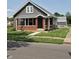 Inviting gray house featuring brick accents, a front porch, and well-maintained landscaping at 1501 California St, Columbus, IN 47201