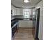 This kitchen features a stainless refrigerator, white cabinets and black countertops at 1501 California St, Columbus, IN 47201