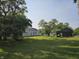 Backyard featuring lush grass, mature trees, storage building and playset at 1510 Chester St, Anderson, IN 46012