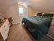 Attic bedroom with carpet, sloped ceilings and comfy green bedding at 1510 Chester St, Anderson, IN 46012