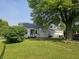 Charming single-story home with a well-maintained lawn, mature trees, and a detached two-car garage at 1510 Chester St, Anderson, IN 46012