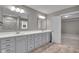 Modern bathroom featuring double vanity with gray cabinetry and large mirrors, flowing into an adjacent room at 15359 Manning Way, Westfield, IN 46074