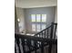 Living room featuring high ceilings, modern fireplace, large windows, and neutral carpet from staircase landing at 15359 Manning Way, Westfield, IN 46074