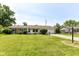 Traditional-style home with manicured front lawn, mature trees, and a paved driveway leading to the garage at 1543 W 79Th St, Indianapolis, IN 46260