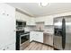 Bright kitchen featuring stainless steel appliances, white cabinets, and updated countertop at 1543 W 79Th St, Indianapolis, IN 46260