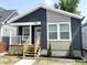 Charming home showcasing dark blue and tan siding and a quaint porch with white railings and wooden stairs at 1628 Spann Ave, Indianapolis, IN 46203