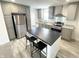 Modern kitchen with gray cabinets, stainless steel appliances, black countertops, and a kitchen island with seating at 1628 Spann Ave, Indianapolis, IN 46203
