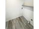 Practical laundry area with wood-look tile flooring and convenient shelving at 1628 Spann Ave, Indianapolis, IN 46203