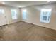 Bright living room featuring neutral carpet, white walls, and natural light through three windows at 1628 Spann Ave, Indianapolis, IN 46203