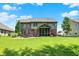 Expansive backyard featuring a screened-in porch, lush lawn, a fire pit, mature landscaping and beautiful two-story home at 1808 Woodfield Dr, Greenwood, IN 46143