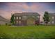 Expansive backyard featuring a screened-in porch, lush lawn, a fire pit, mature landscaping and beautiful two-story home at 1808 Woodfield Dr, Greenwood, IN 46143