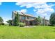 Spacious backyard featuring a screened-in porch, lush lawn, a fire pit, mature trees and a beautiful two-story home at 1808 Woodfield Dr, Greenwood, IN 46143