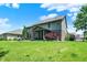 Expansive backyard featuring a screened-in porch, lush lawn, a fire pit, mature landscaping and beautiful two-story home at 1808 Woodfield Dr, Greenwood, IN 46143
