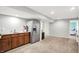 Basement with a stainless steel refrigerator and dark wood cabinets by a door and open space at 1808 Woodfield Dr, Greenwood, IN 46143