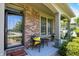 Inviting front porch with a seating area, brick siding, and decorative flower basket at 1808 Woodfield Dr, Greenwood, IN 46143