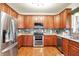 This kitchen features stainless steel appliances, cherry cabinets, and hardwood floors at 1808 Woodfield Dr, Greenwood, IN 46143