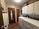 Convenient laundry room with modern washer and dryer, plus ample cabinet space for storage at 1837 Bauer Rd, Indianapolis, IN 46218