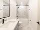 Modern bathroom boasts a granite sink, marble tile floor and shower over tub at 2051-2053 Columbia Ave, Indianapolis, IN 46202