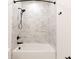 Modern bathroom with white marble-style tile, black fixtures, and a combined shower and tub at 2051-2053 Columbia Ave, Indianapolis, IN 46202