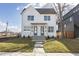 Charming new construction duplex with white siding, a manicured lawn, and concrete steps leading to the front doors at 2051-2053 Columbia Ave, Indianapolis, IN 46202
