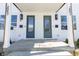 Close up of the front porch of the duplex featuring two front doors and stylish exterior lanterns at 2051-2053 Columbia Ave, Indianapolis, IN 46202