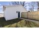 A detached garage with white siding, a contrasting blue door, and a new wooden fence at 2051-2053 Columbia Ave, Indianapolis, IN 46202