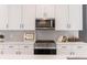 Close-up of a modern kitchen featuring white cabinets, subway tile backsplash, and stainless steel appliances at 2051-2053 Columbia Ave, Indianapolis, IN 46202