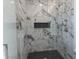 Luxurious marble tiled shower features black herringbone floor and a built-in niche at 2051-2053 Columbia Ave, Indianapolis, IN 46202