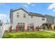 Backyard of a two-story home featuring a well-maintained lawn, outdoor dining area, and white fencing for privacy at 210 Lynnette Way, Cumberland, IN 46229
