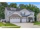 Charming two-story home with stone accents, a two-car garage, a beautifully landscaped yard, and an inviting front porch at 210 Lynnette Way, Cumberland, IN 46229