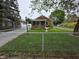 Charming single story home featuring a well-manicured lawn and a chain link fence at 2411 Harlan St, Indianapolis, IN 46203