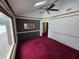 Bright living room with a fan, carpet floors, and skylights, providing natural light at 2411 Harlan St, Indianapolis, IN 46203