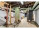 Unfinished basement with exposed ductwork, old brick support columns, concrete flooring, and stairway at 3018 S Anthony Blvd, Fort Wayne, IN 46806