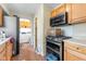 This kitchen features wood cabinets, modern appliances, and convenient access to the laundry room for added functionality at 3018 S Anthony Blvd, Fort Wayne, IN 46806