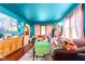 Living room with bright teal walls, hardwood floors, a purple couch and natural light from the windows at 3018 S Anthony Blvd, Fort Wayne, IN 46806