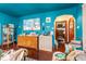 The living room features bold teal walls and ceiling with natural wood floors, creating a unique and inviting space at 3018 S Anthony Blvd, Fort Wayne, IN 46806