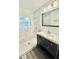Bright bathroom featuring shower with marble-look tile and a modern vanity at 3103 Keswick Rd, Indianapolis, IN 46222