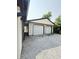 View of the detached two-car garage with white doors and gravel driveway at 3103 Keswick Rd, Indianapolis, IN 46222
