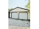 Detached two-car garage featuring white doors, black trim and a gravel driveway at 3103 Keswick Rd, Indianapolis, IN 46222