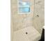 Beautiful shower featuring marble-look tiling, a window, and a hexagon tiled floor at 3103 Keswick Rd, Indianapolis, IN 46222