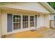 Charming covered front porch with wood decking, white door, and blue shutters on the windows at 3149 Carson Ave, Indianapolis, IN 46227