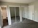 Bedroom with plush carpeting, mirrored closet doors, and adjacent bathroom at 3259 Pawnee Dr, Indianapolis, IN 46235