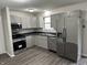 Modern kitchen with stainless steel appliances, gray cabinetry, and dark countertops at 3259 Pawnee Dr, Indianapolis, IN 46235
