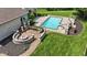 Backyard aerial view of a custom pool and patio with a fire pit and a manicured lawn at 3795 Claybrook Ct, Bargersville, IN 46106