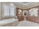 Luxurious bathroom with soaking tub, shuttered window, and custom vanity offering a spa-like experience at 3795 Claybrook Ct, Bargersville, IN 46106