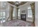 Comfortable bedroom with a fireplace, ceiling fan, rug, and large windows with decorative curtains at 3795 Claybrook Ct, Bargersville, IN 46106