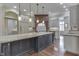 Bright kitchen with neutral paint, island with granite countertop, pendant lighting, and hardwood floors at 3795 Claybrook Ct, Bargersville, IN 46106